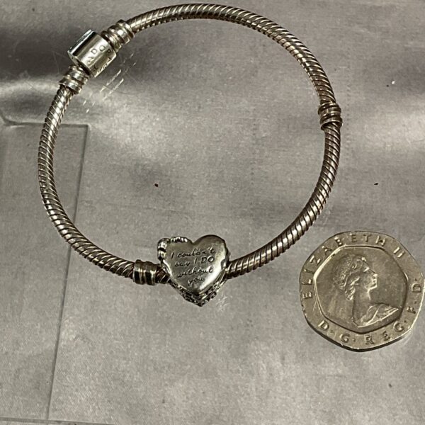 Silver Pandora heart charm bracelet, delicate jewellery detail.