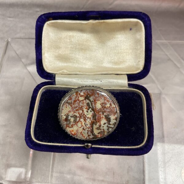 Close-up of a vintage granit brooch with a floral design.