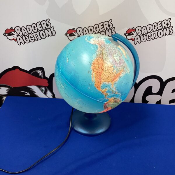 Vintage illuminated world globe on a metal base.