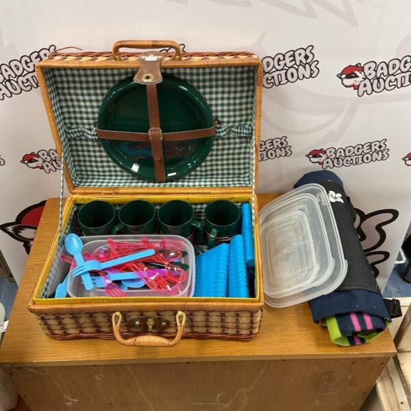 Vintage picnic hamper set with blanket and dining essentials.