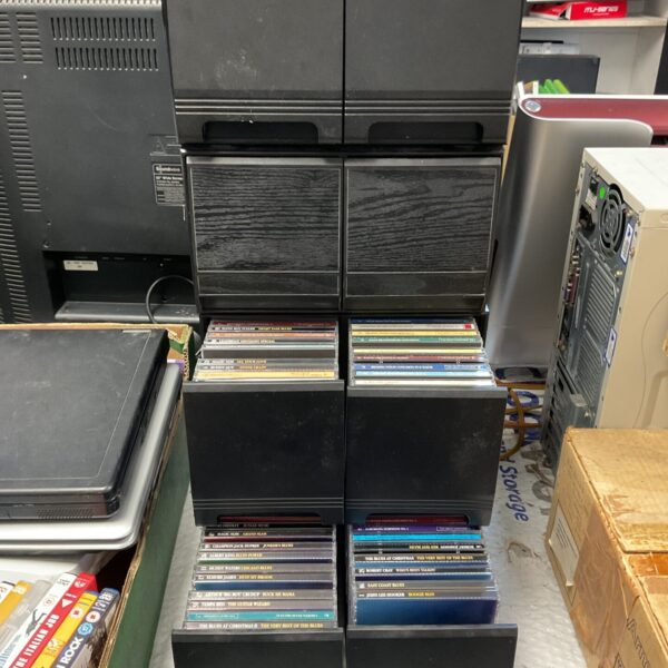 Black CD rack filled with a large collection of CDs for music storage.