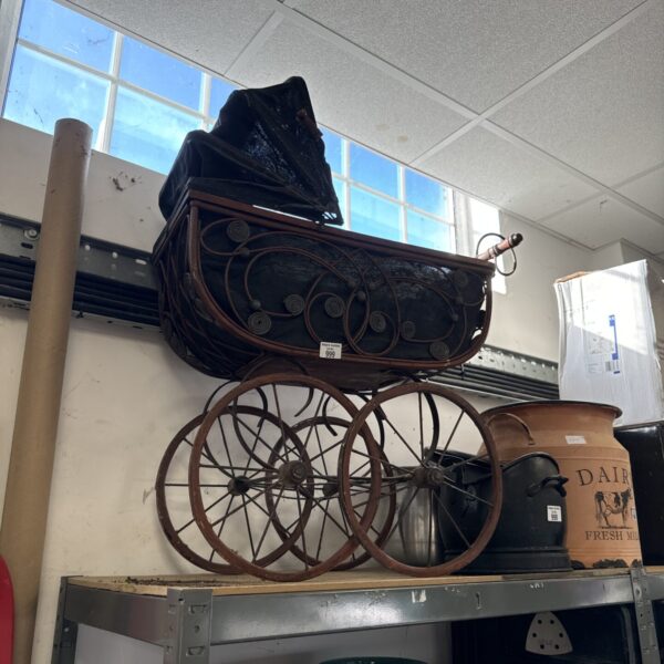 Antique wooden doll pram with spoked wheels, vintage toy.