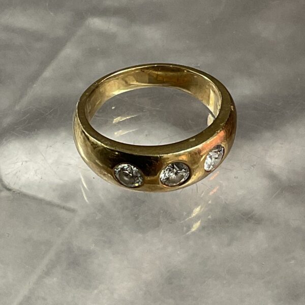 Close-up of a 9ct gold diamond ring with three stones.