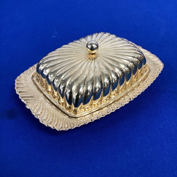 Elegant gold tone butter dish with decorative lid.