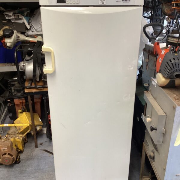 White Miele tall freezer with damage to the door.