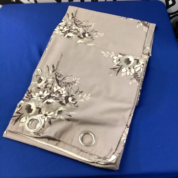 Pair of grey floral curtains with eyelet heading.