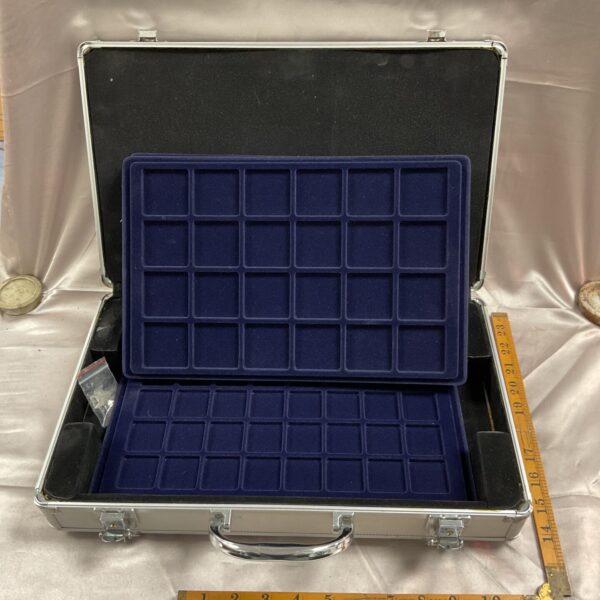 Open aluminium coin collectors case with blue velvet interior.