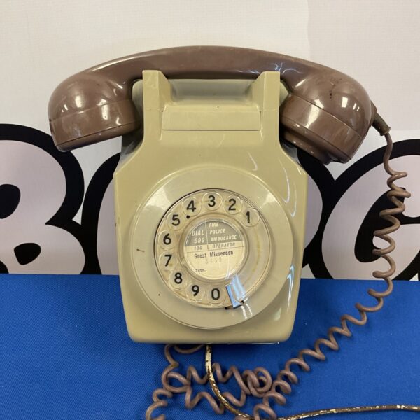 Close-up of a vintage rotary telephone with a coiled cord.