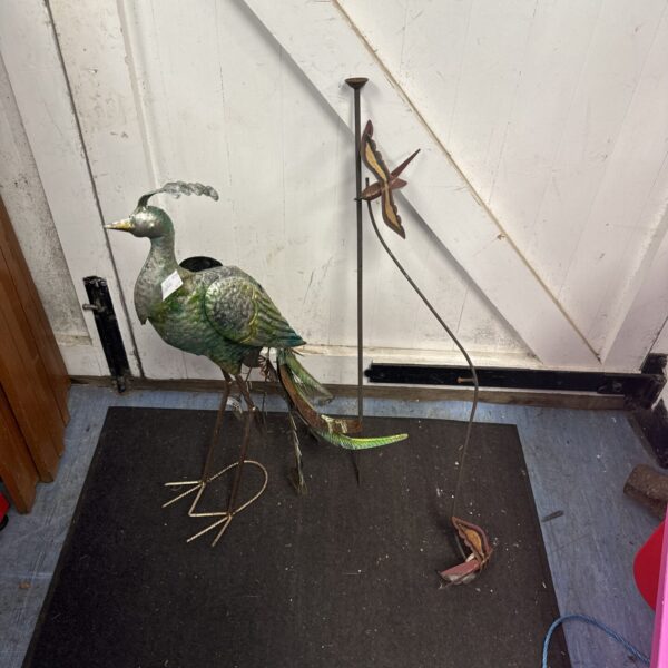Vibrant metal garden peacock ornament with wind spinner tail.