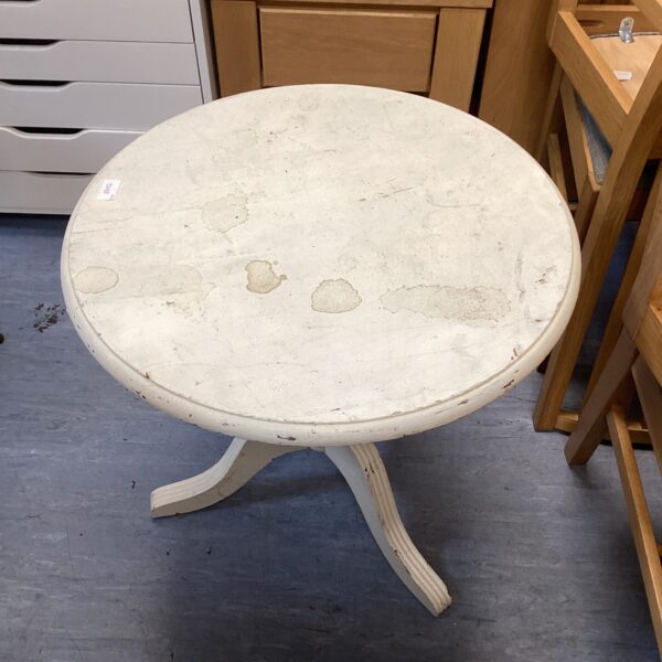 White shabby chic round table with tripod legs.