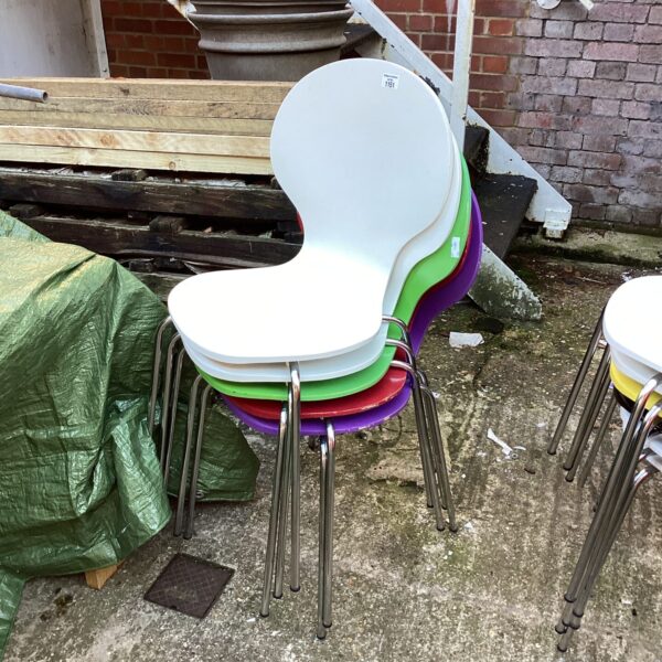 Group of four vintage plastic stacking chairs in bright colours.