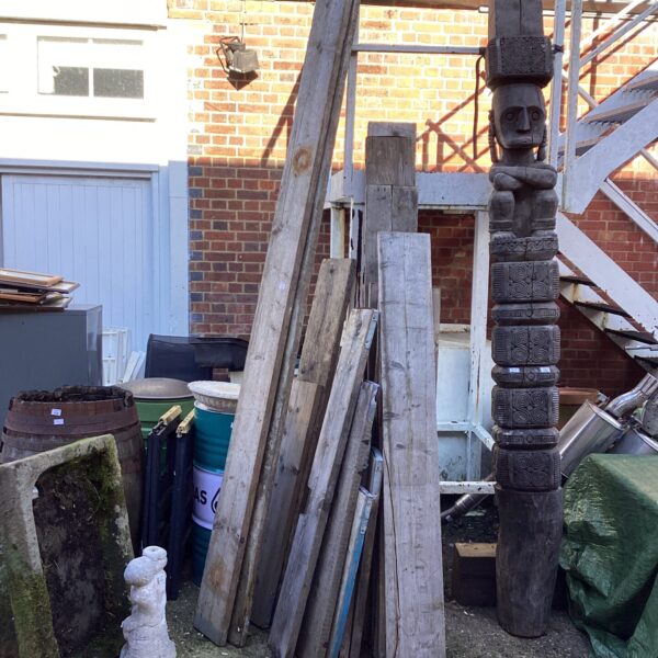 Reclaimed scaffolding boards and a carved wooden post in a garden setting.