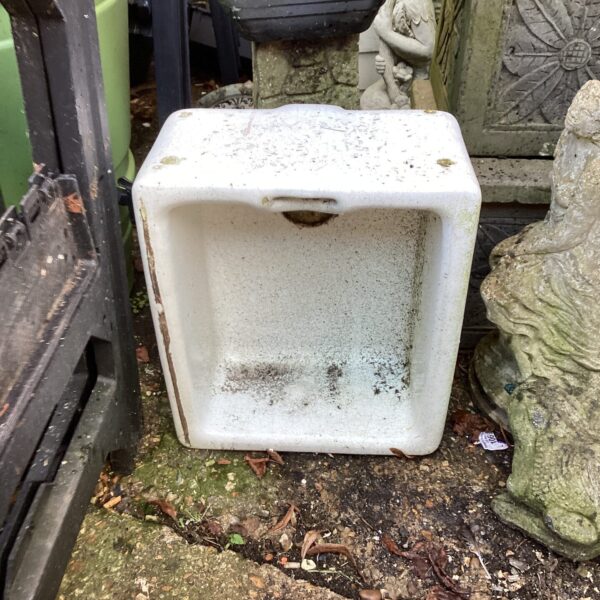 Vintage Belfast sink repurposed as a unique garden planter.