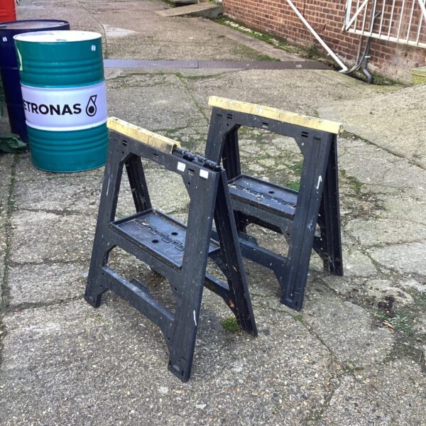 Pair of metal workmans tressels in a workshop setting.