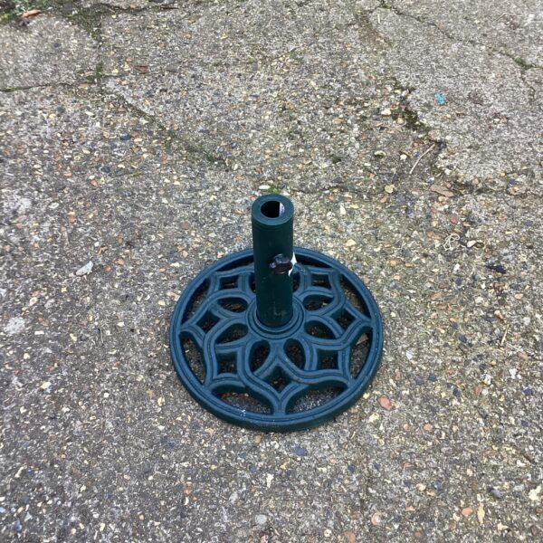 Ornate metal parasol base for garden or patio use.