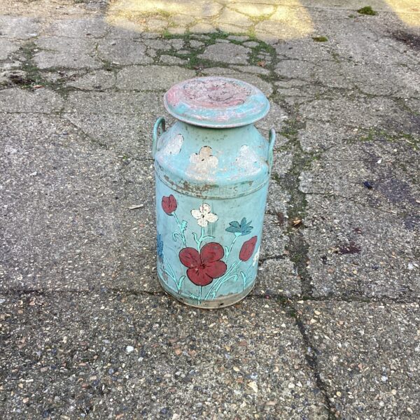 Vintage metal milk churn with floral design, farmhouse decor.
