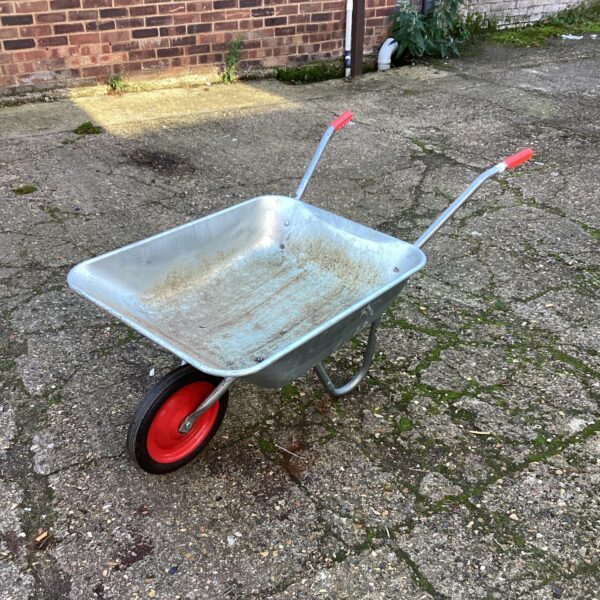 Metal wheelbarrow for garden use, showing signs of wear.