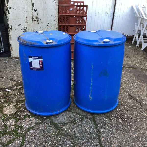 Two dark plastic drums for industrial storage and repurposing.