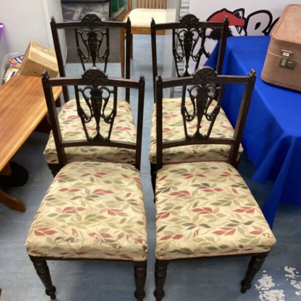 Set of four antique dining chairs with patterned upholstery.