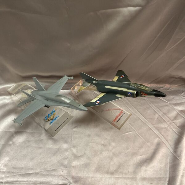 Detailed model Phantom F4 and FA18 Hornet fighter jets on stands.