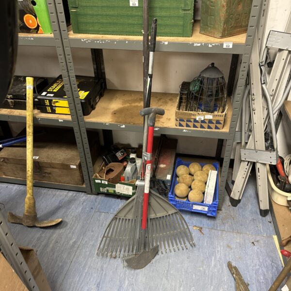 Lot of garden tools including a lawn edger and rakes.