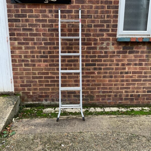 Silver aluminium multi function ladder leaning against a brick wall.