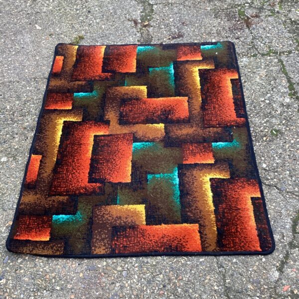 Orange and brown patterned rug with geometric design.