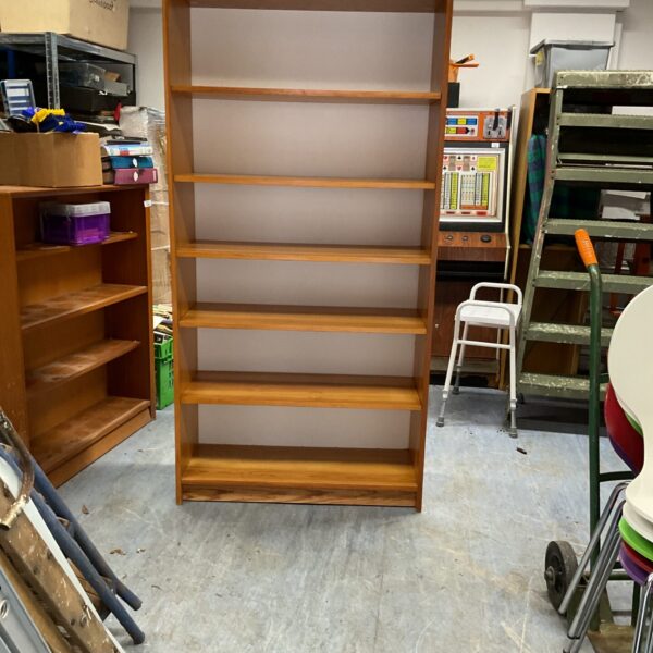 Tall oak effect bookcase with multiple shelves for storage.