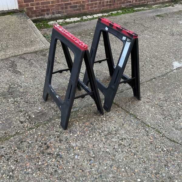 Black folding sawhorses, a practical pair for DIY and garden work.