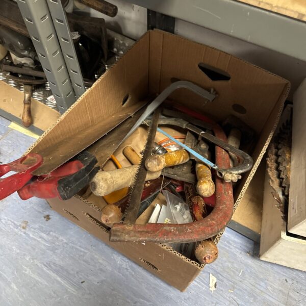 Assorted vintage hand tools in a cardboard box.