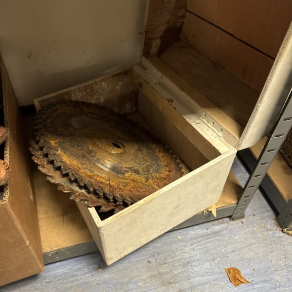 Vintage circular saw blades inside a wooden box.