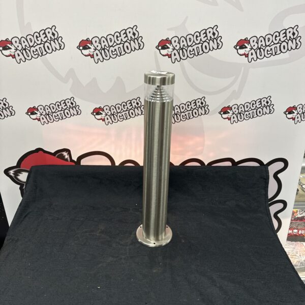 Stainless steel outdoor LED post light against a backdrop.