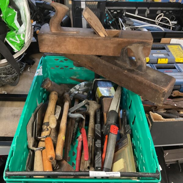 Crate filled with assorted hand tools and garden implements.