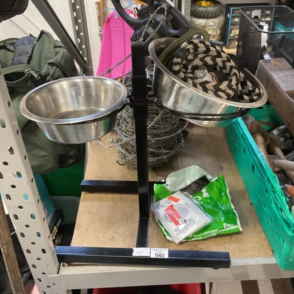 Black raised dog feeding station with stainless steel bowls and leads.