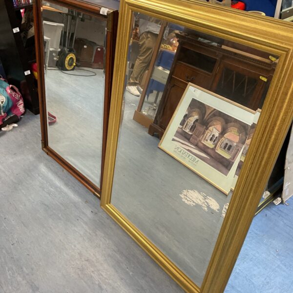 Large antique gilded framed mirror with ornate detailing.