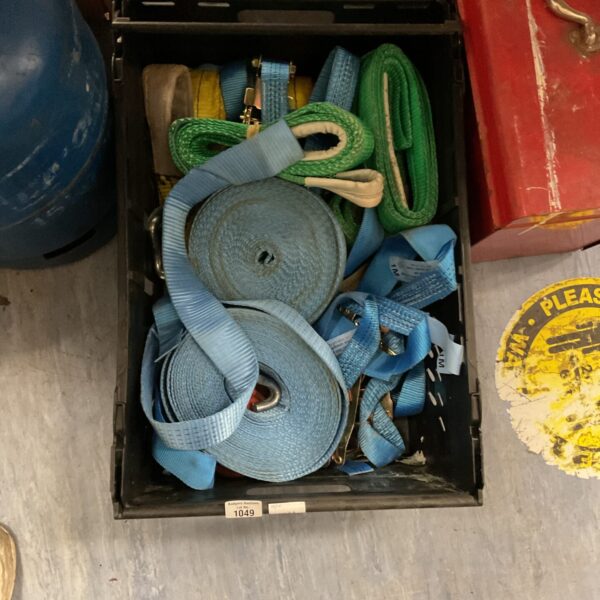 Lot of blue and green ratchet straps for securing cargo.