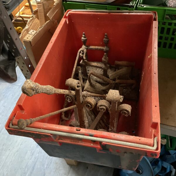 Antique wrought iron fire dogs in a box, ready for restoration.