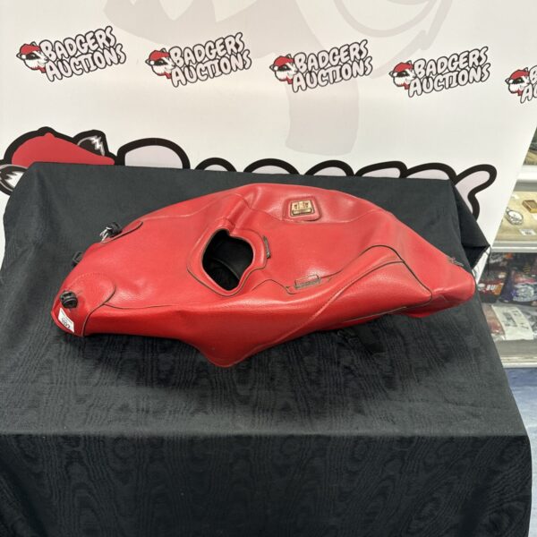 Red leather Bagster motorcycle fuel tank cover for protection.