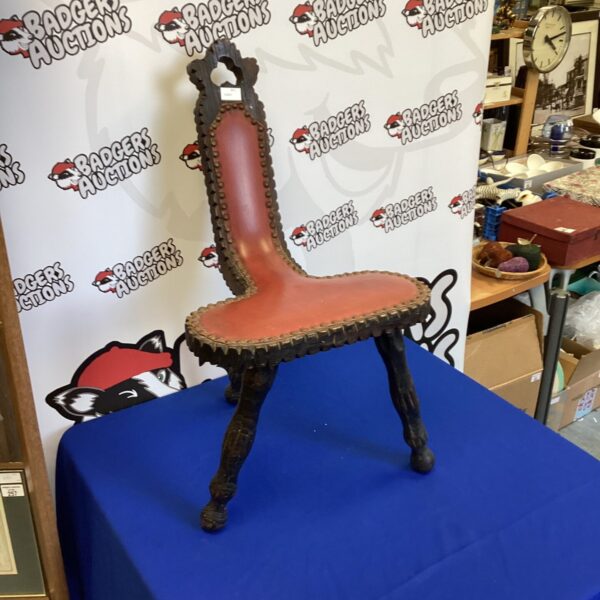 Vintage French three-legged chair with carved details.