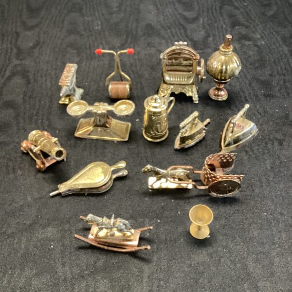 Vintage gilt metal dolls house furniture collection on display.