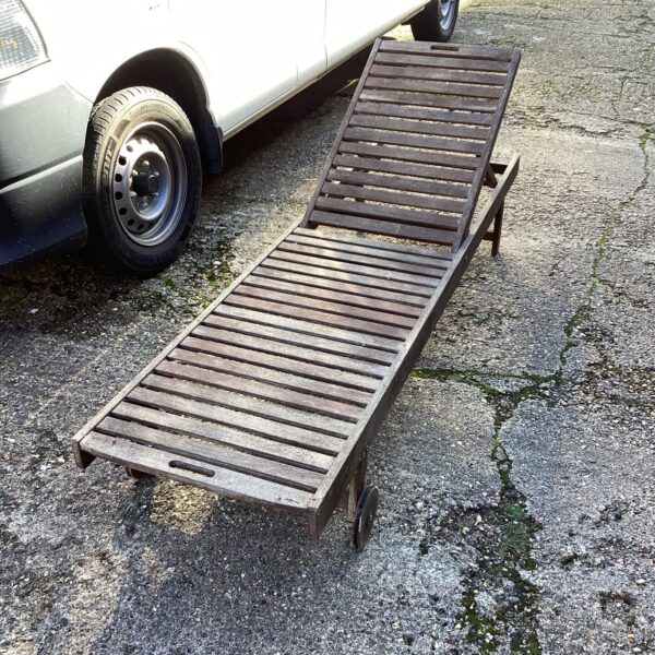 Vintage teak garden lounger in a garden setting.