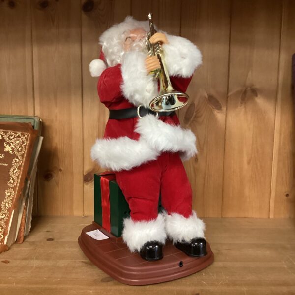 Vintage musical Santa Claus playing a trumpet, Christmas decoration.