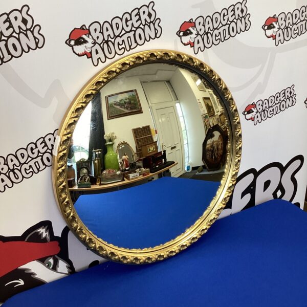 Vintage convex mirror with ornate gilt frame, antique wall decor.
