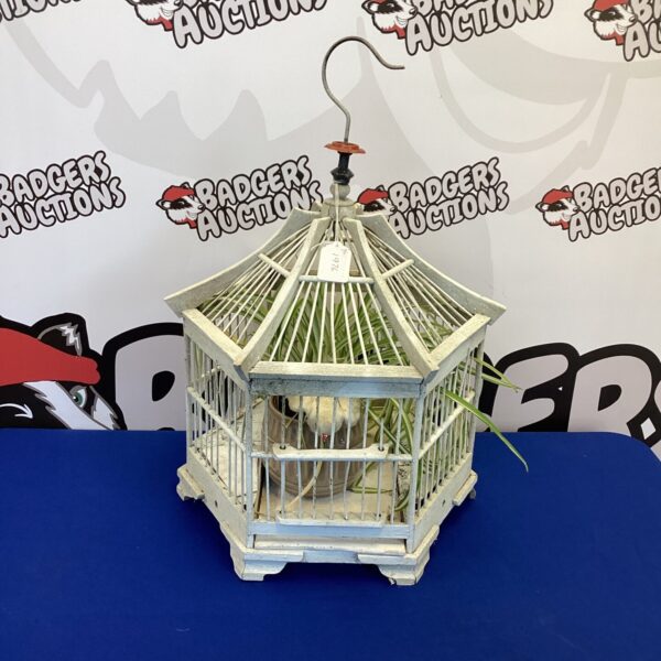 Wooden Japanese bird cage with artificial plant inside.
