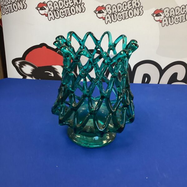 Handmade teal art glass candle holder with intricate design.