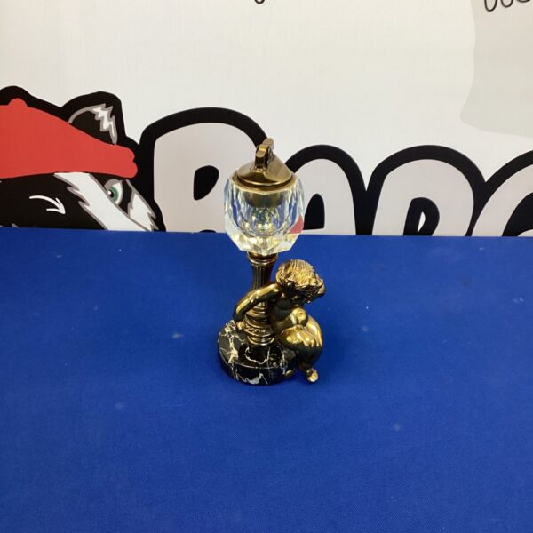 Vintage cherub table lighter with clear glass reservoir.