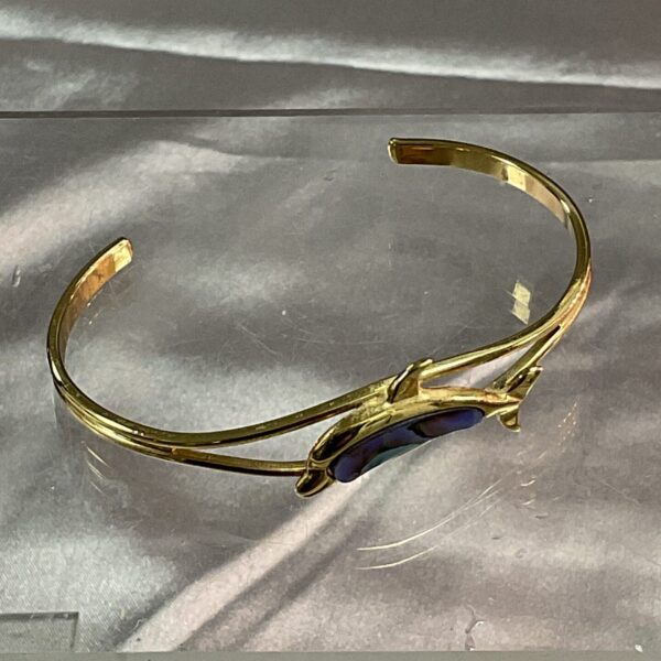 Vintage yellow metal dolphin bracelet with iridescent butterfly wing.