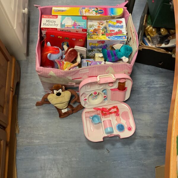 Mixed toy lot with baby doll, board games, and soft toys.