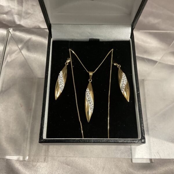 Sparkling 9ct gold pendant and earrings set on display.
