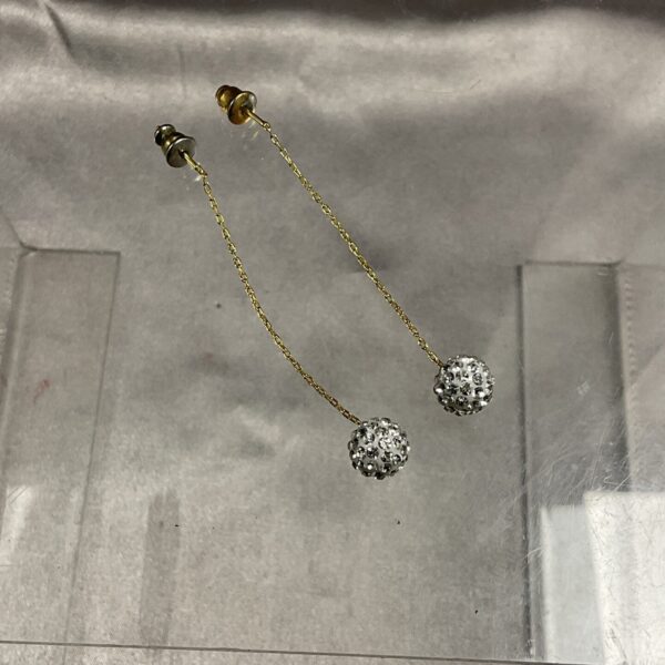Close-up of vintage 9ct gold snowball earrings on a neutral background.